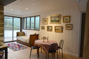 Una habitación acogedora con una cama, una mesa de comedor con sillas y un ventanal con vistas al exterior.