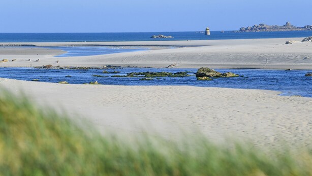 A beach with sand, water, and rocks. - Entre Terre et Mer (Plougoulm)