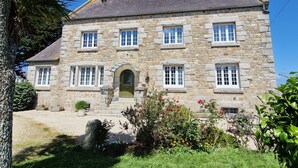 A stone building with a symmetrical facade, multiple windows, and a central entrance. - Entre Terre et Mer (Plougoulm)