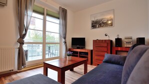 A living room with a sofa, a coffee table, a TV, and a cabinet. - Victus Apartamenty - Petit (Sopot)
