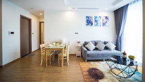 Een moderne woonkamer met een eethoek, een bank en abstracte kunst aan de muur.