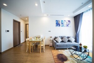 Una sala de estar moderna con comedor, un sofá y arte abstracto en la pared.