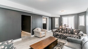 A modern living room with a sofa, armchair, and coffee table. - Beach1 Riverfront Resort - #32 - Wasaga Beach (Wasaga Beach)
