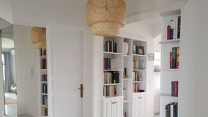 Ein Flur mit weißen Wänden, einem Marmorboden und Bücherregalen voller Bücher.