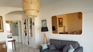 Ein modernes Wohnzimmer mit einem grauen Sofa, einem Holztisch und einem Webteppich.