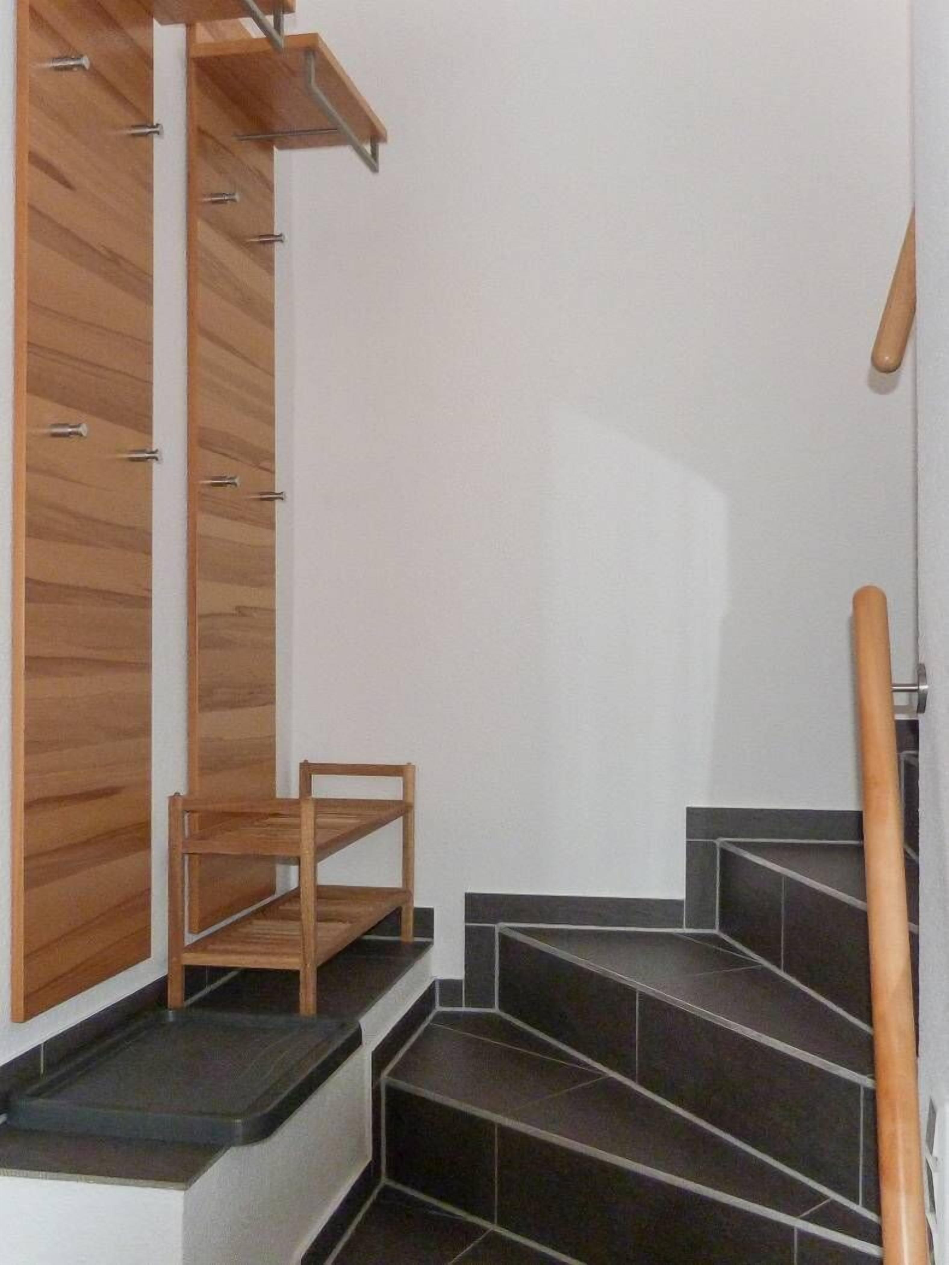 A staircase with wooden steps and a chair at the bottom.
