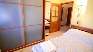 Un dormitorio con cama, armario de madera y espejo.