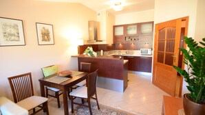 Una cocina compacta con comedor, armarios de madera y una isla central.