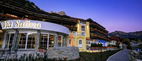 A hotel named "Via Salina" with a stone facade, large windows, and a pathway leading to the entrance.