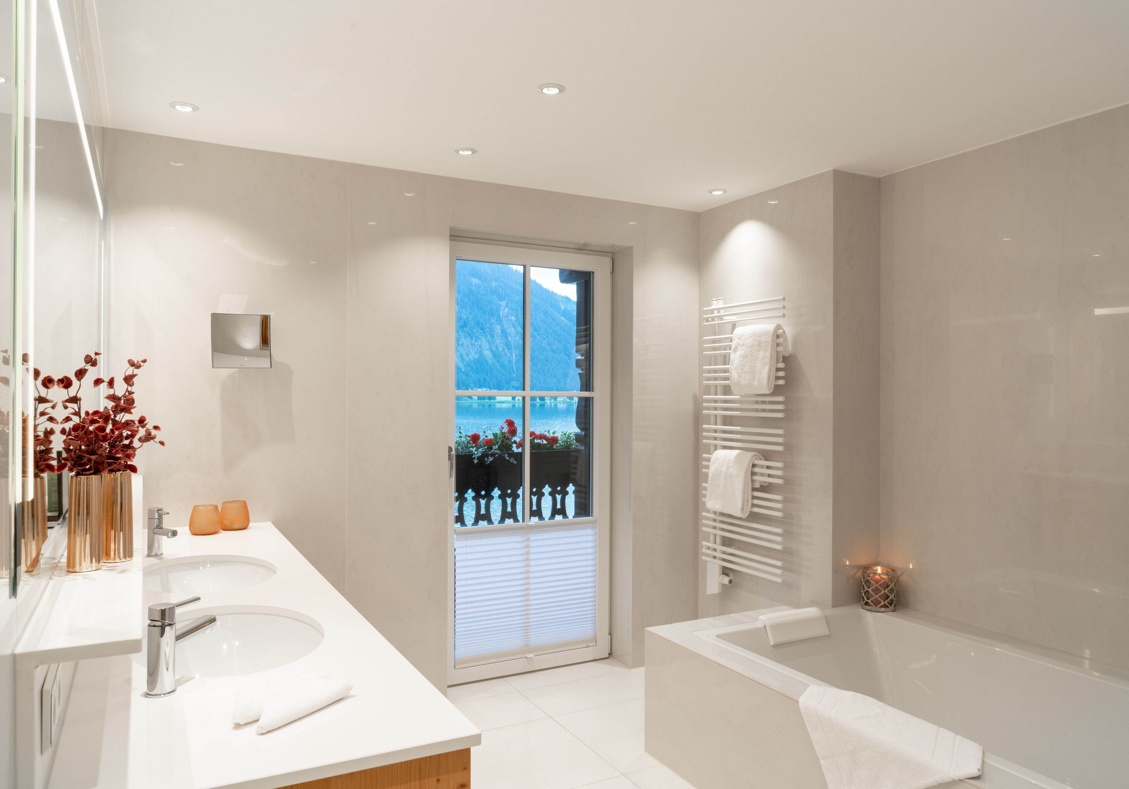 Un baño moderno con un ventanal grande, una bañera y un lavabo doble.