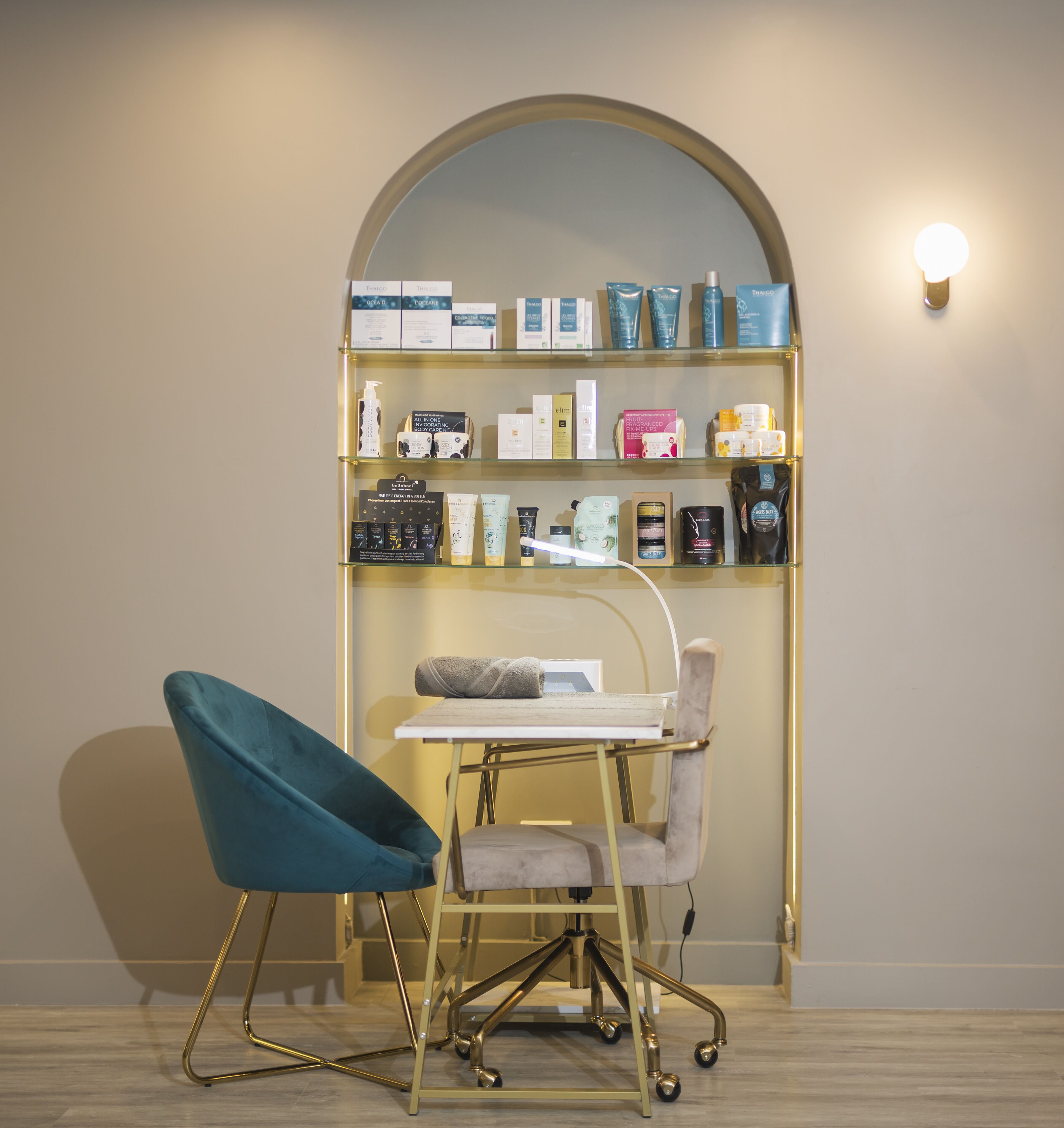A room with a desk, chair, and a shelf with various products.