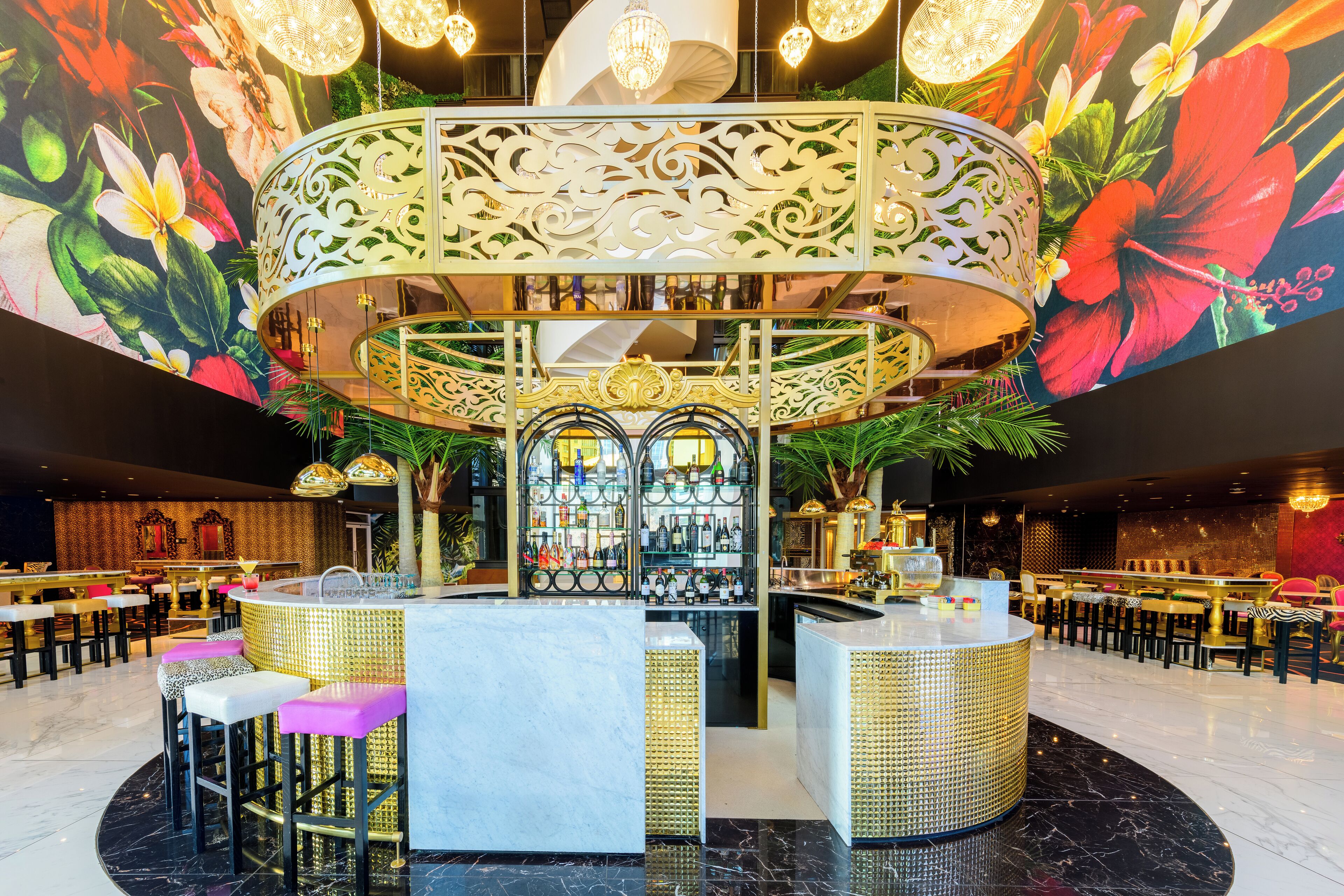 Zona de bar con diseño circular, taburetes y una sala de estar con mesas.
