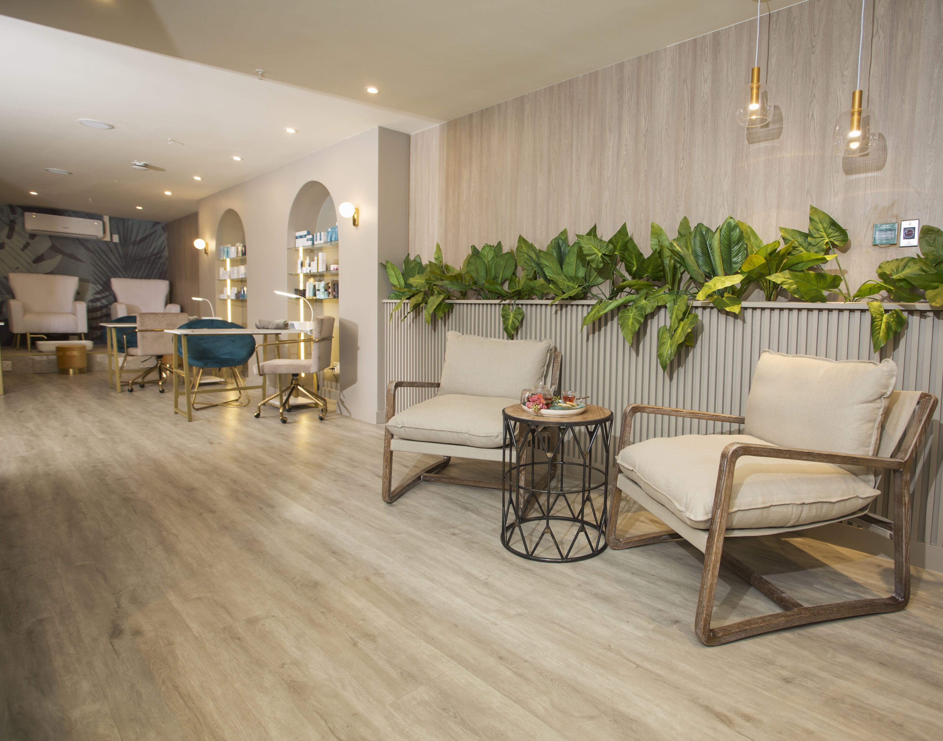A modern living room with a wooden floor, two armchairs, a small round table, and a wall-mounted plant display.