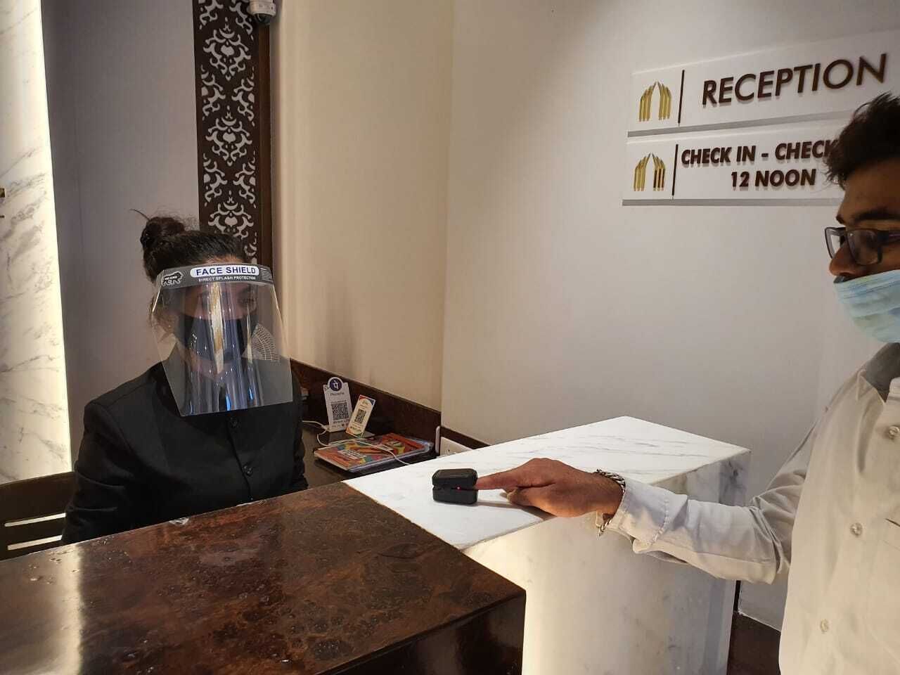 Zona de recepción con un cartel que indica registro de entrada a las 12 del mediodía.