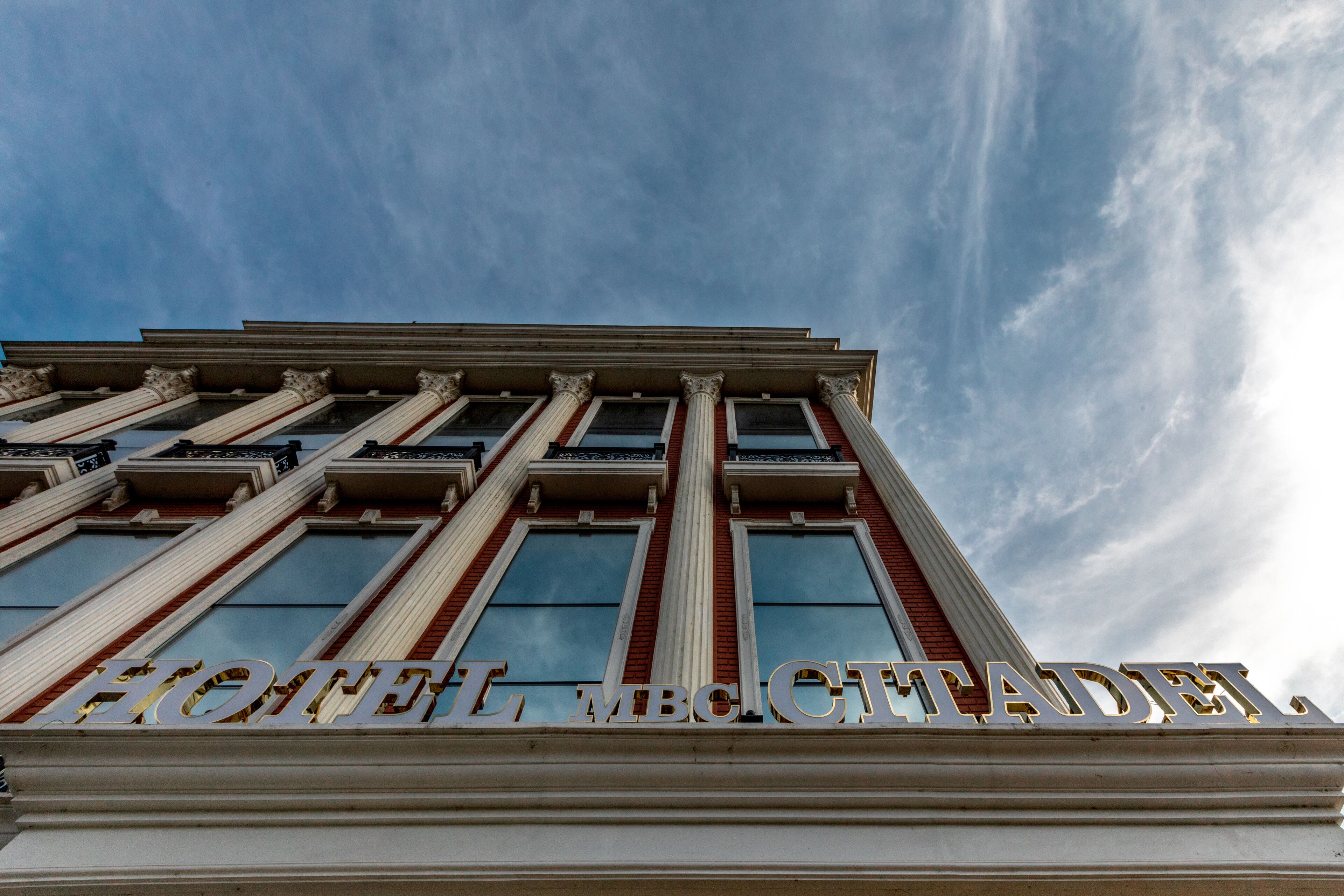 A hotel sign with columns and large windows.