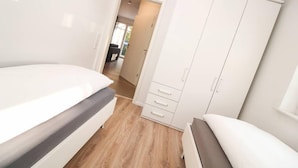 Une chambre à coucher avec un lit, une armoire et un banc.