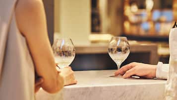 Una mesa con cubierta de mármol y dos copas de vino.