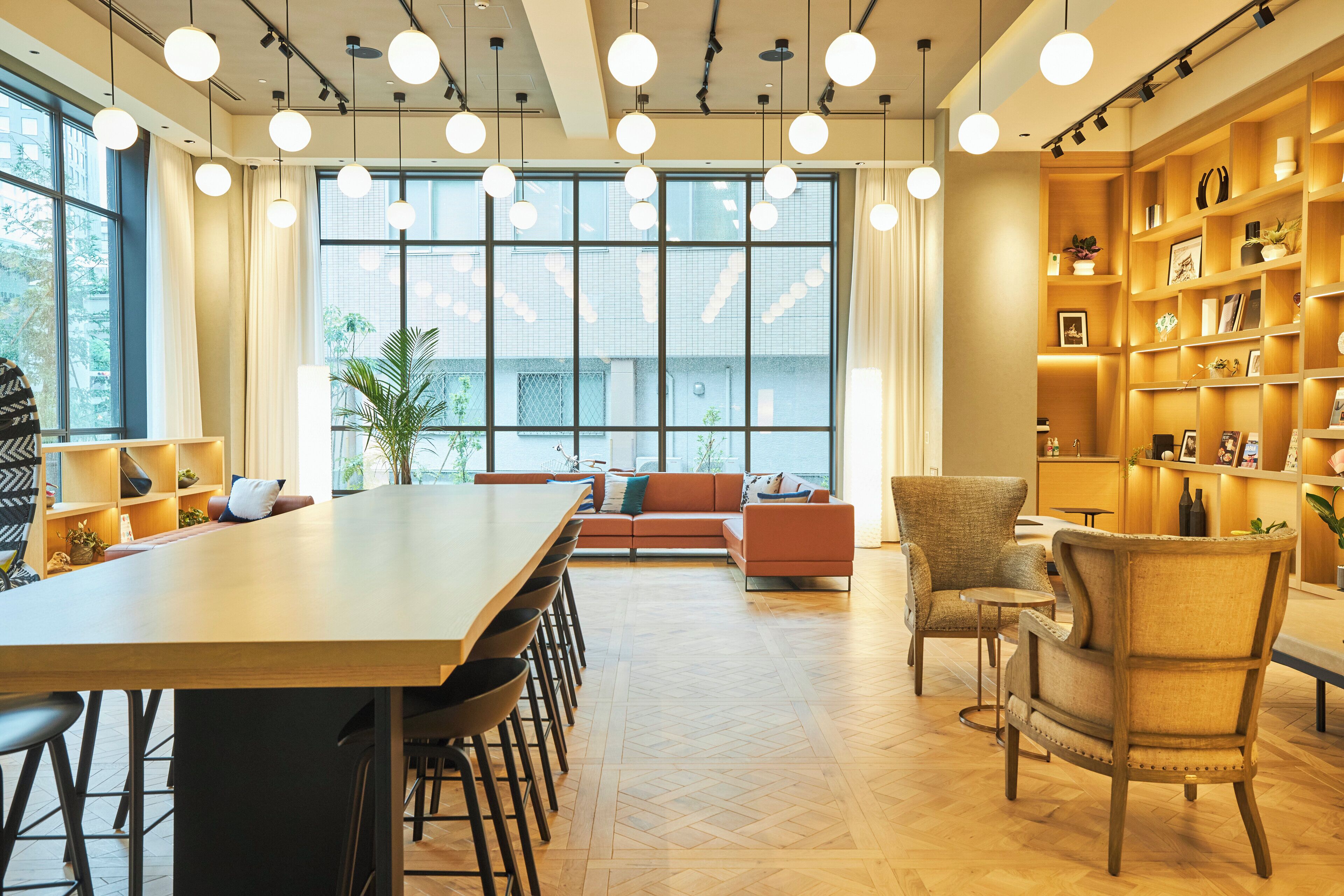 Un interior moderno con una mesa de comedor de madera, sillas, un sofá y una estantería.