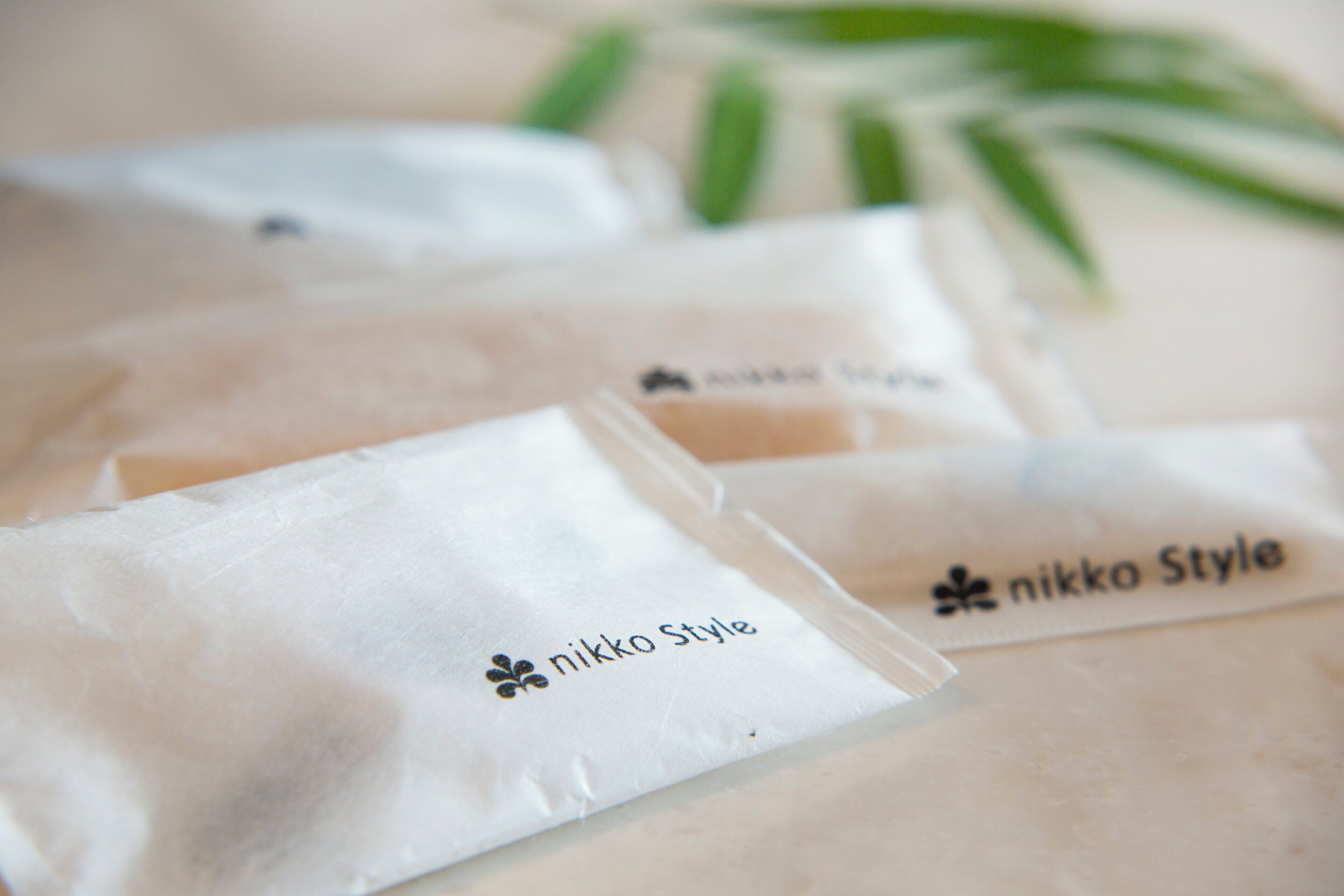 Three white paper bags with "nikko Style" branding.