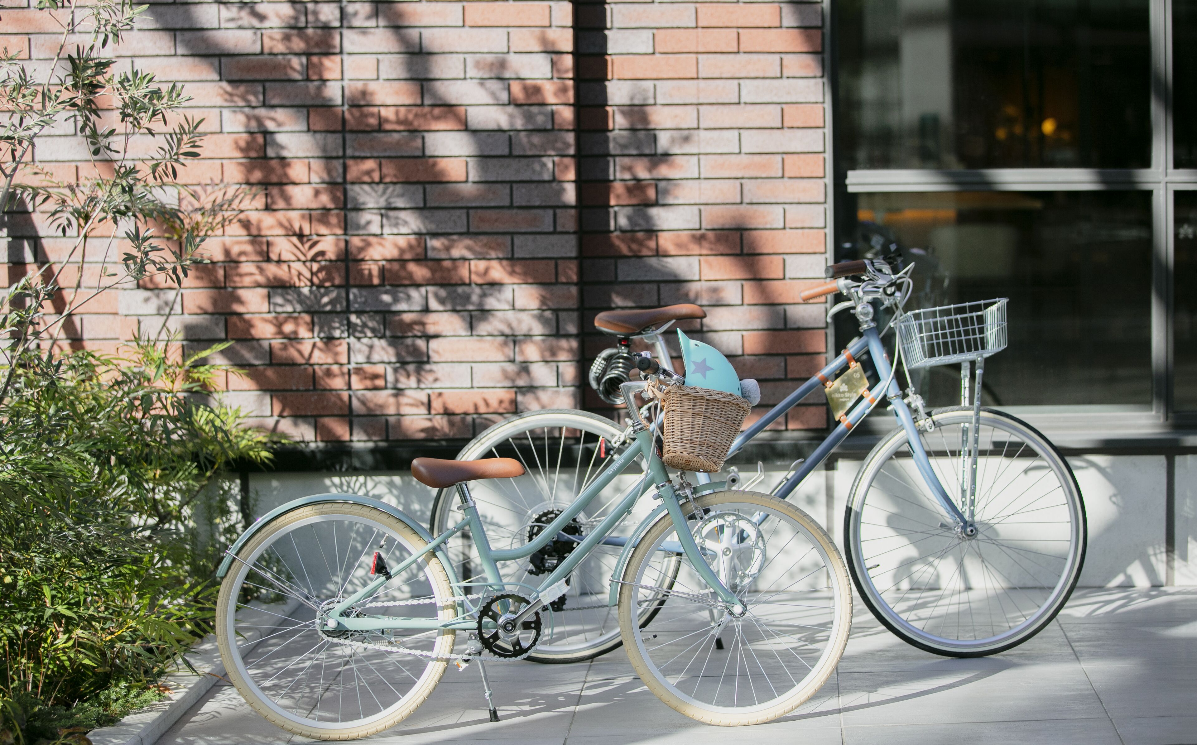 A bicycle parked on a sidewalk next to a brick building.