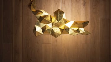 A geometric light fixture on a wooden wall.