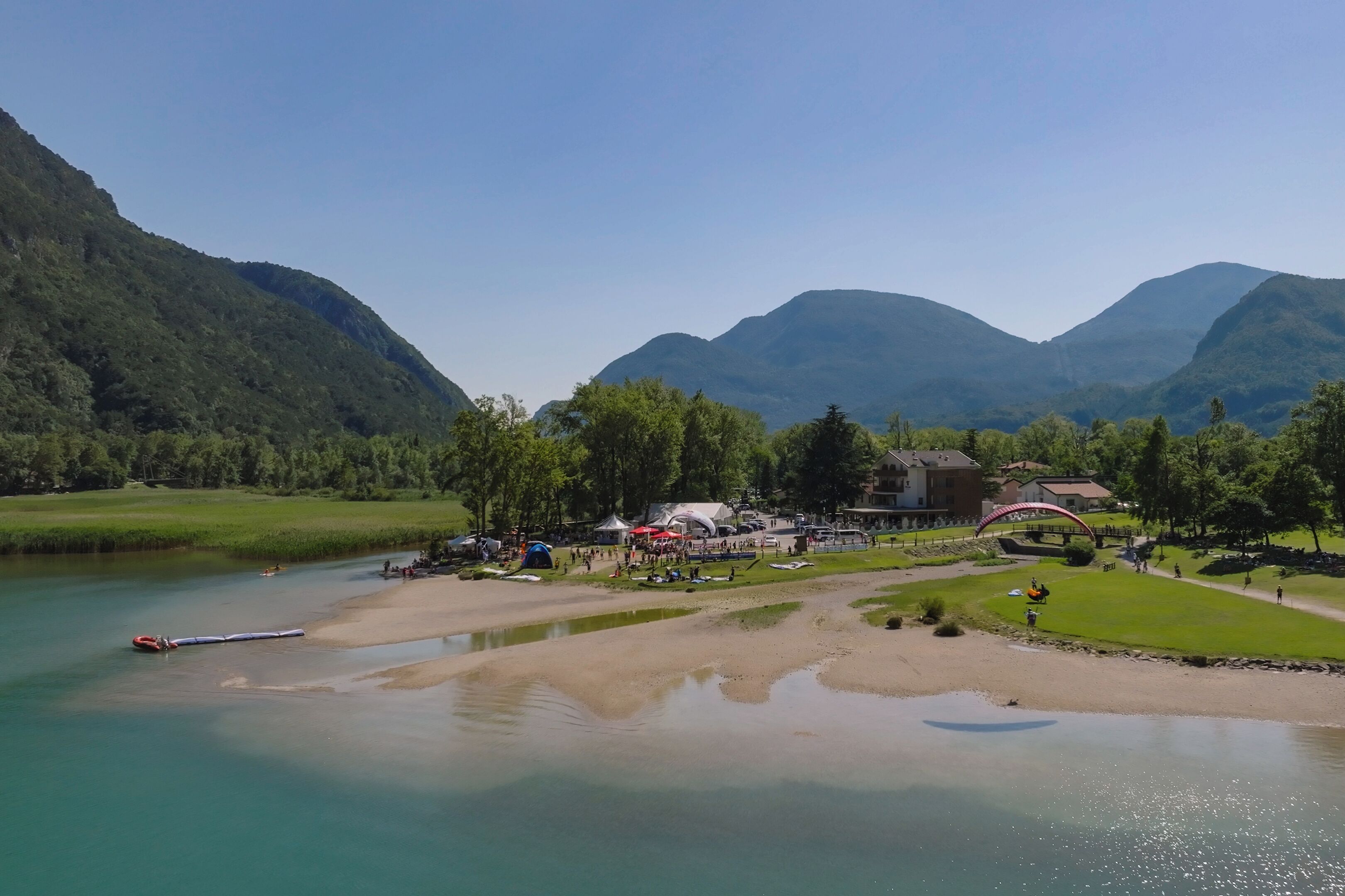Vista sul fiume con un molo per barche, tende e un ponte.
