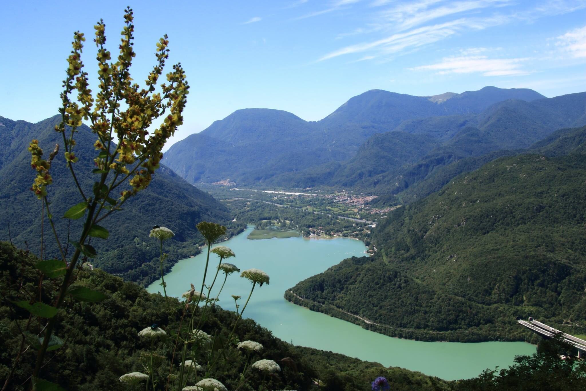 Paisagem montanhosa com rio e ponte.