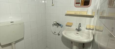 A bathroom with a toilet, sink, and shower.