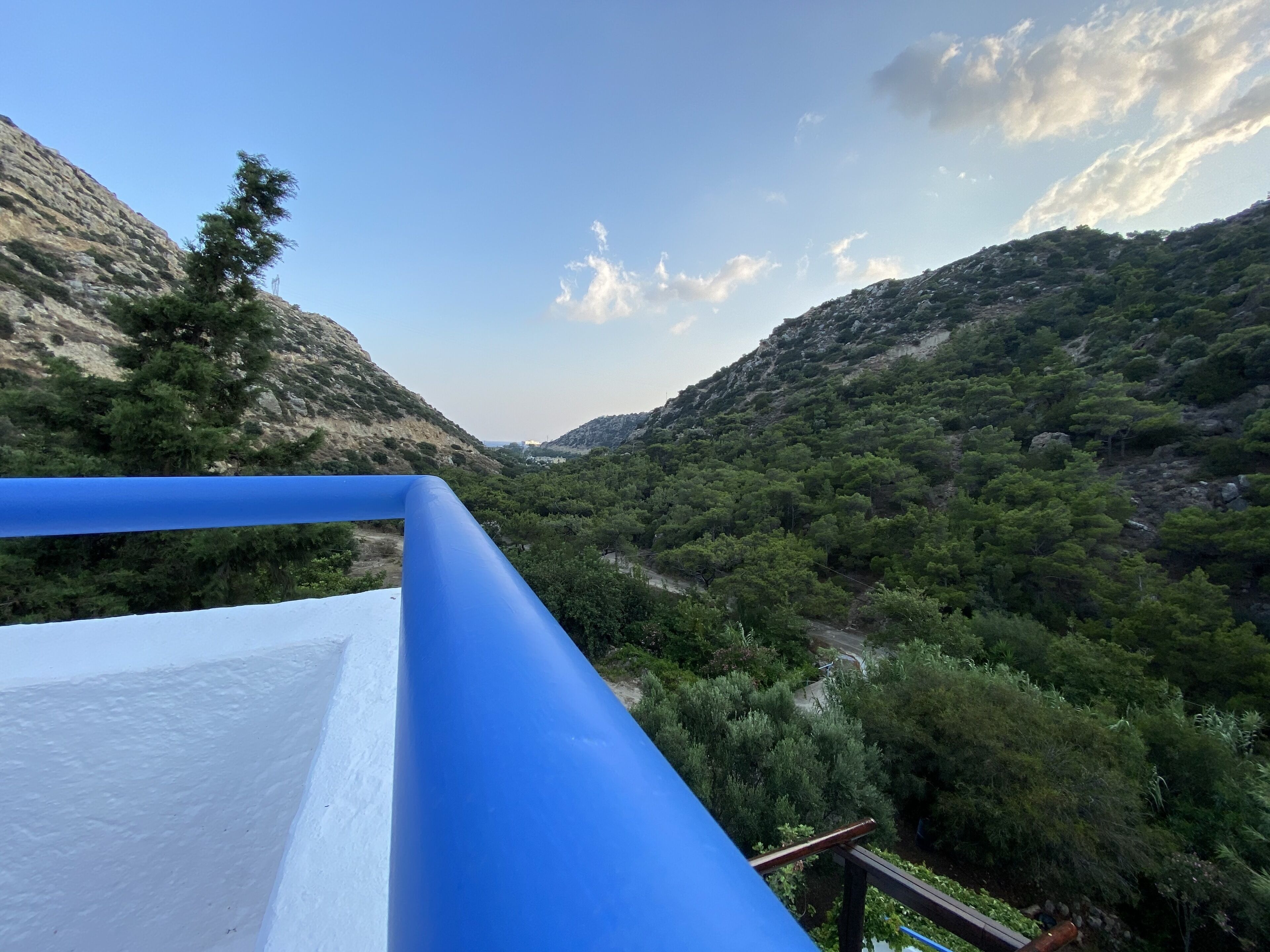 A mountainous landscape with dense greenery and a clear sky.