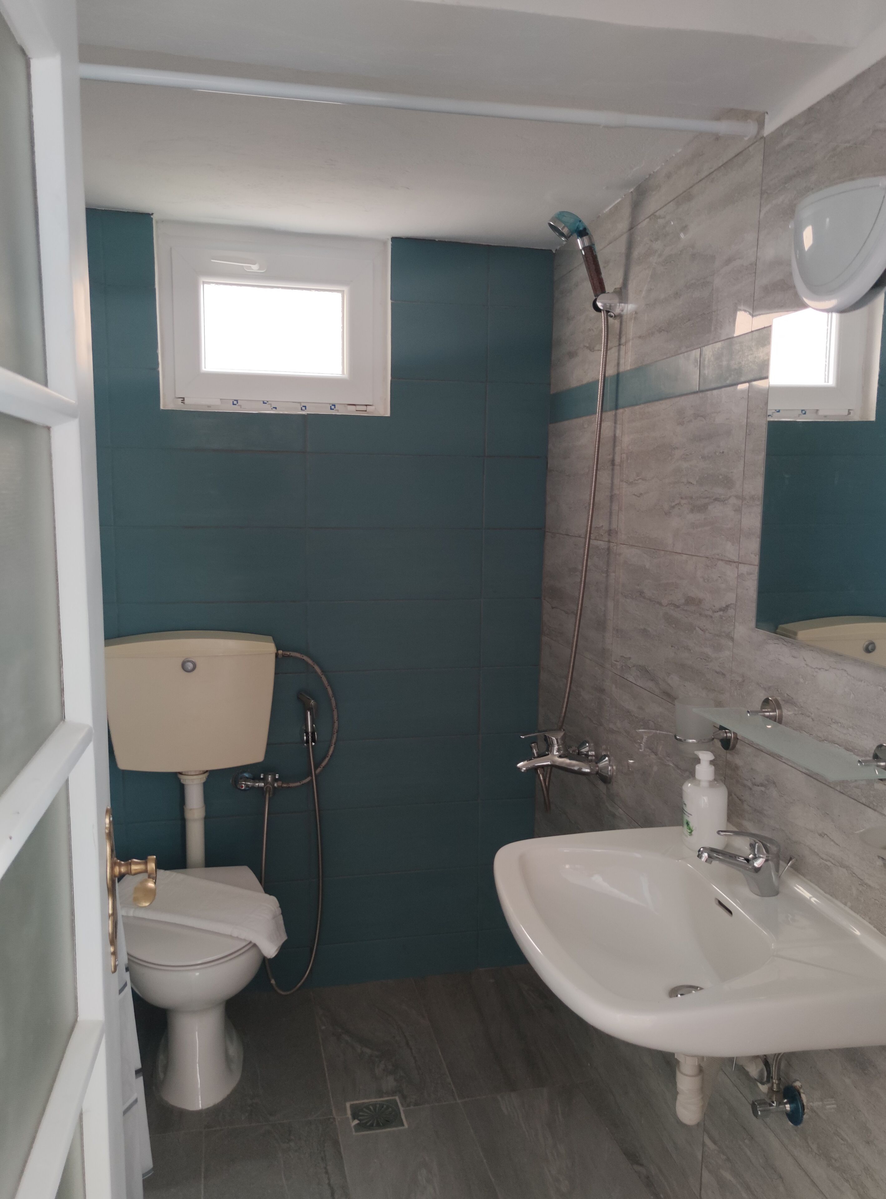 A bathroom with a toilet, sink, and shower.