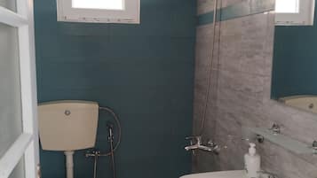 A bathroom with a toilet, sink, and shower.