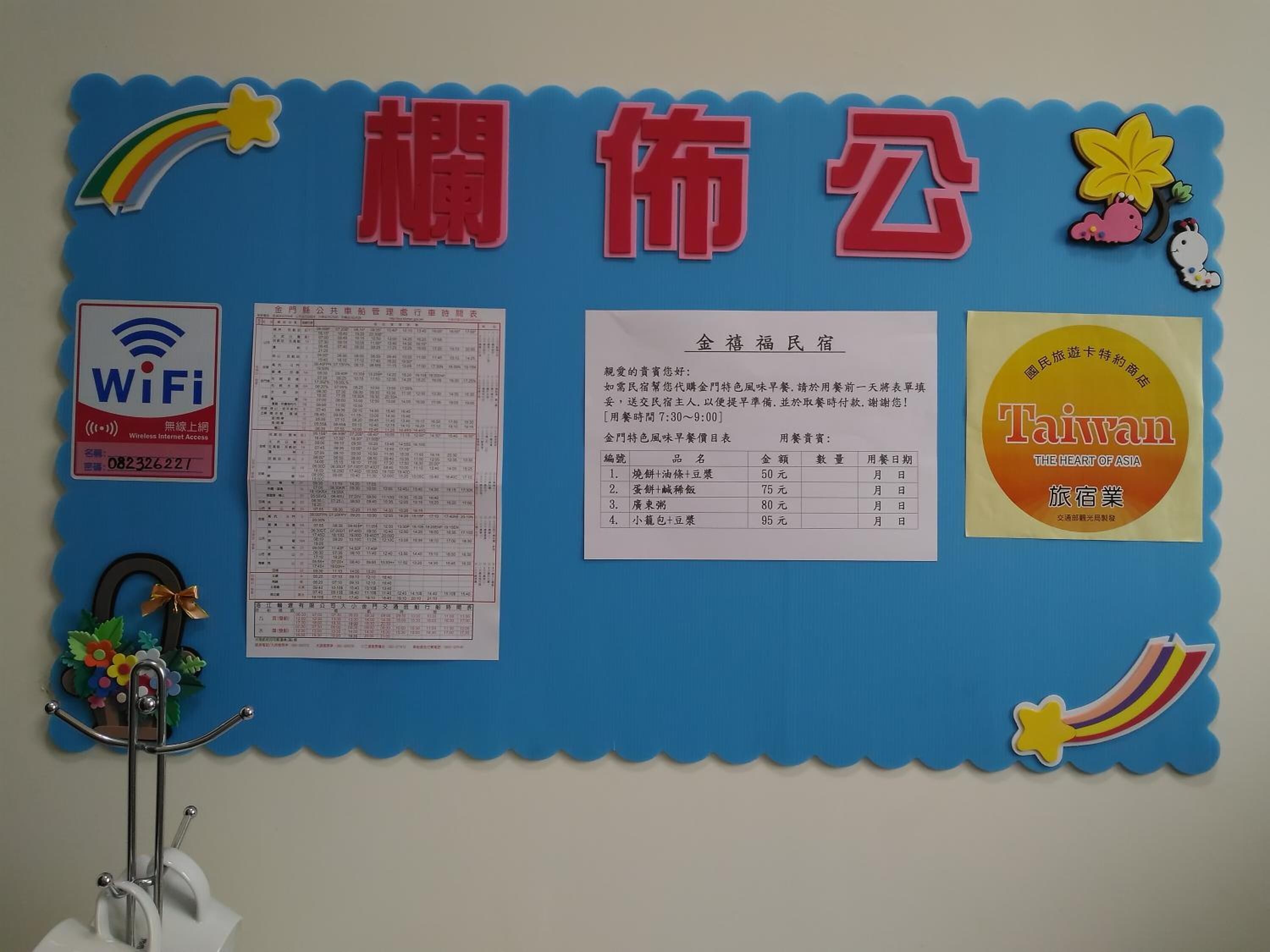 A bulletin board with various notices and information, including a WiFi sign, a menu, and a Taiwan travel advertisement.