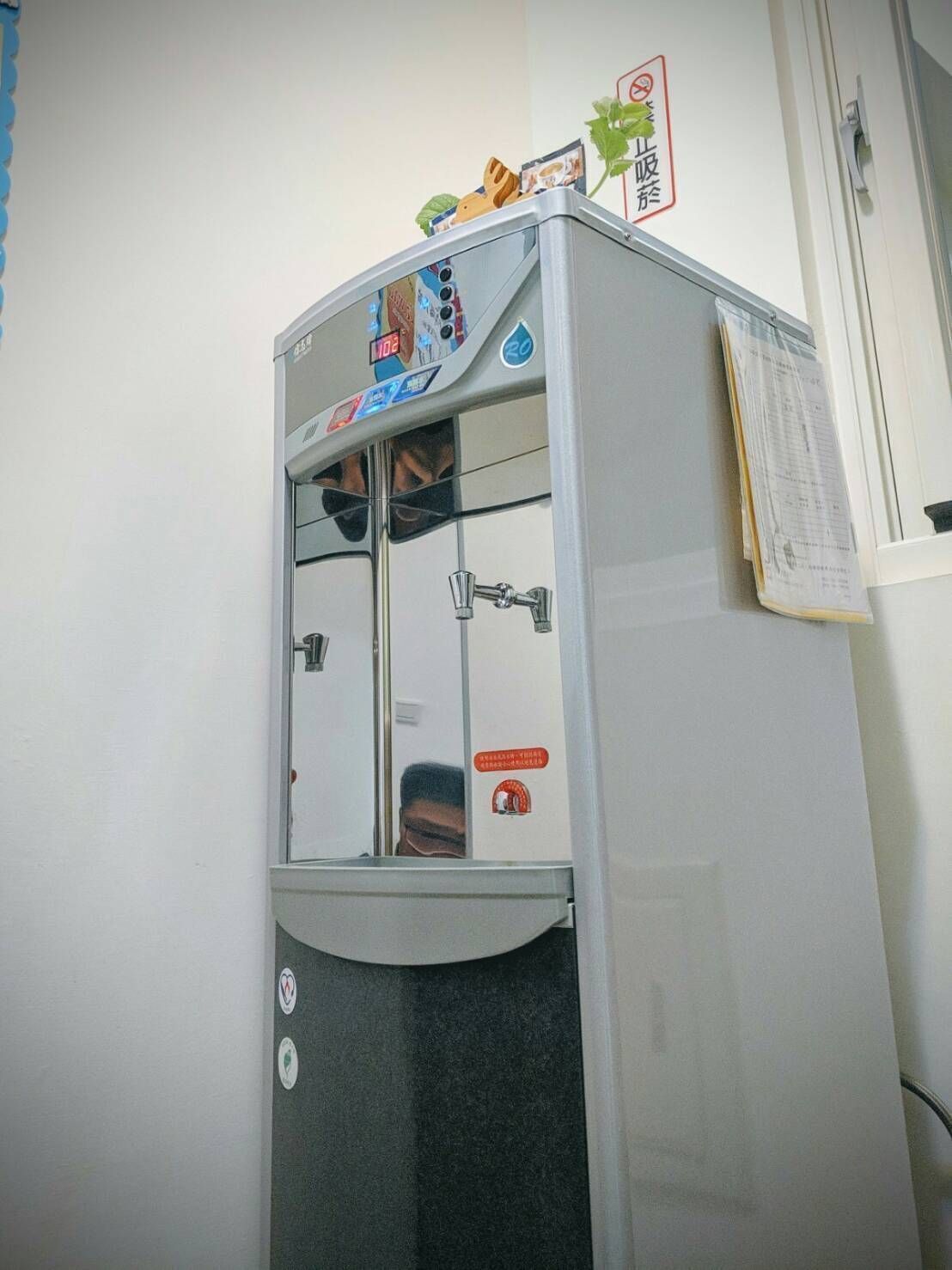 Un distributeur d’eau doté d’un écran numérique, une bouteille d’eau et un distributeur d’essuie-tout.