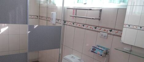 Ein Badezimmer mit Toilette, Waschbecken und Duschbereich.