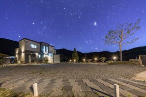 A modern building with a gravel driveway and a starry night sky. - Nine to zero Pension (Hongcheon)