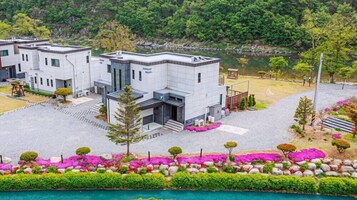Un edificio moderno con techo plano, forma rectangular y un patio empedrado.