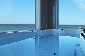 A modern, spacious hot tub with a clear view of the ocean. - Gangnung SS Pension (Gangneung)
