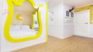 Un dormitorio con un espejo grande, una cama, una puerta blanca y una pared de ladrillo.