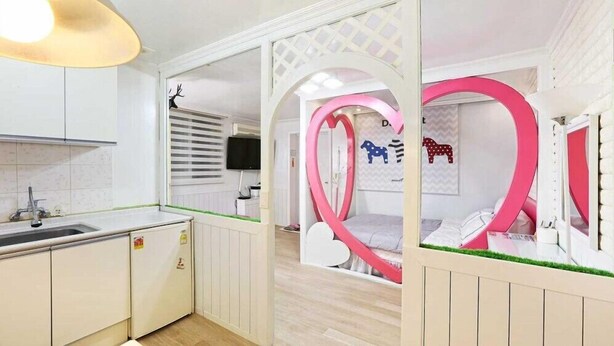 A child's bedroom with a bed, a heart-shaped window frame, and a wall with animal silhouettes. - Herb Story Pension (Chuncheon)