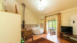 A modern living room with a fireplace, a sofa, a television, and a large window with curtains. - Yangpyung Lavin Pension (Yangpyeong)