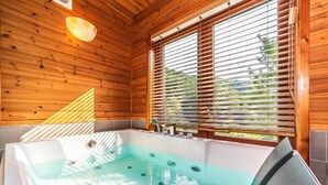 A wooden cabin with a hot tub, wooden walls, and a window with blinds. - Yangpyung Lavin Pension (Yangpyeong)