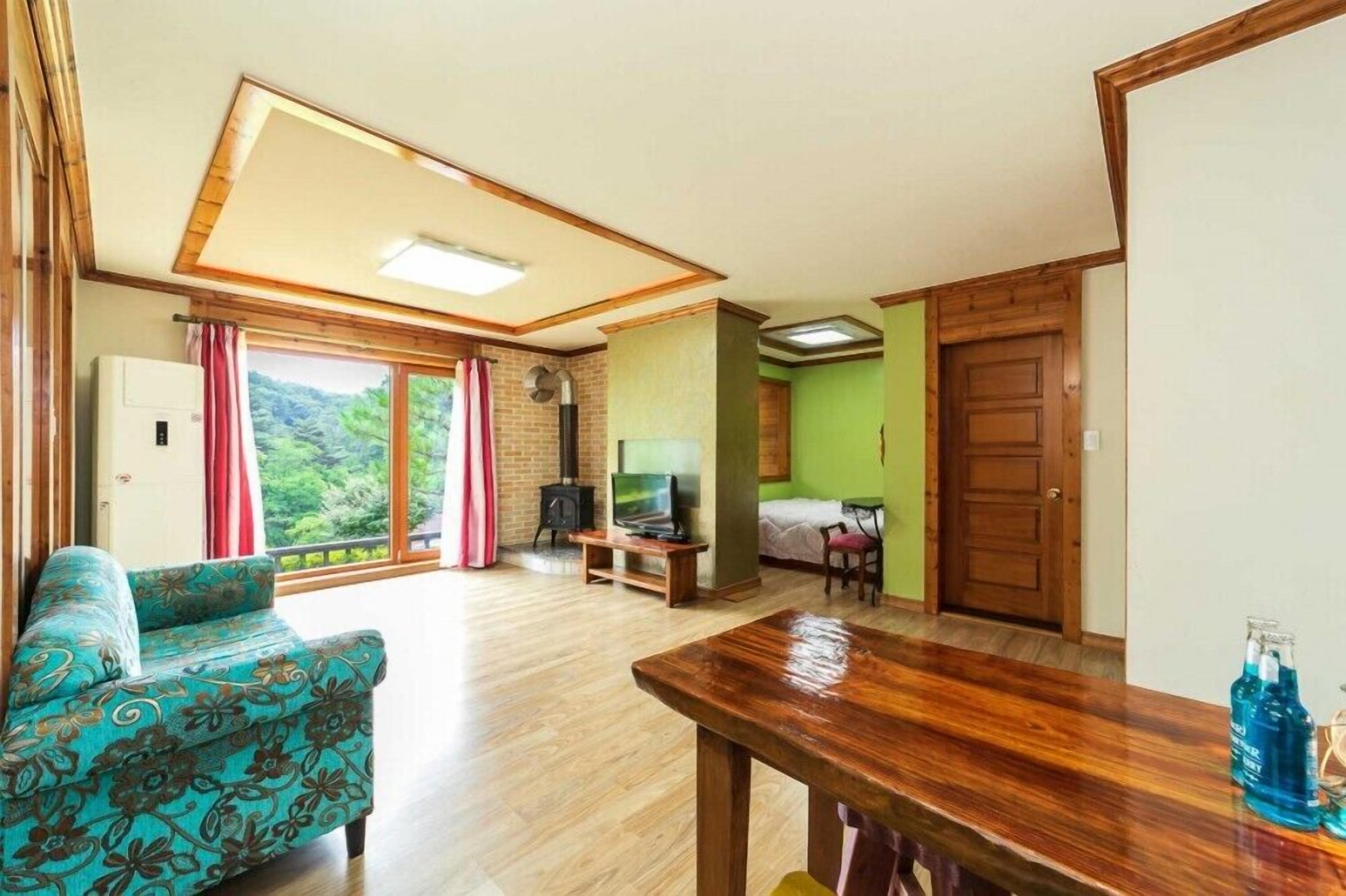 Una sala de estar acogedora con un sofá, una mesa de comedor de madera, un televisor y una chimenea.