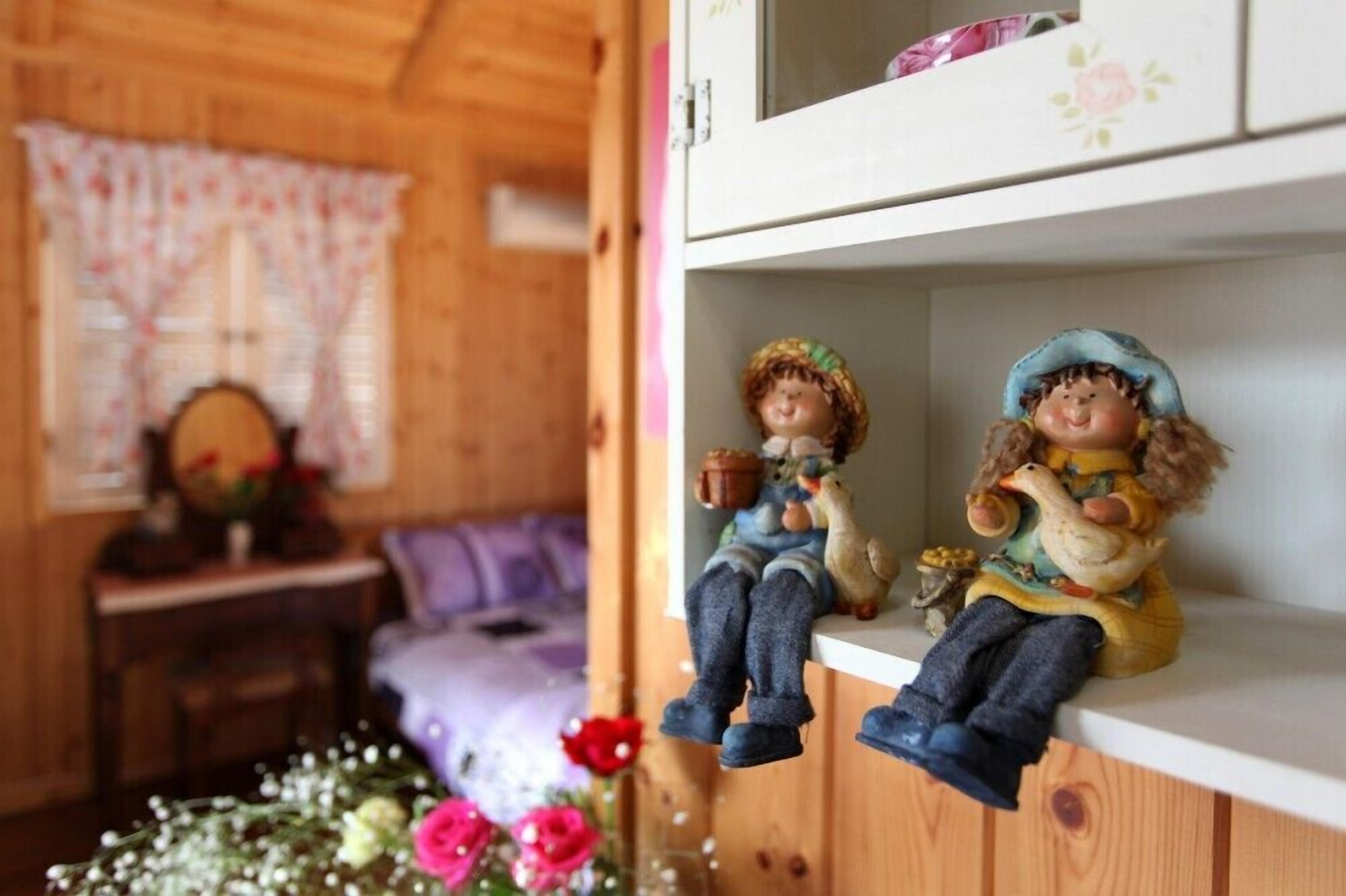 A wooden interior with a shelf holding two figurines.