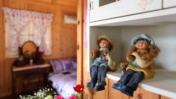 A wooden interior with a shelf holding two figurines.