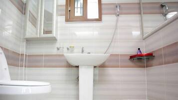 A bathroom with a white sink, a toilet, and a shower.
