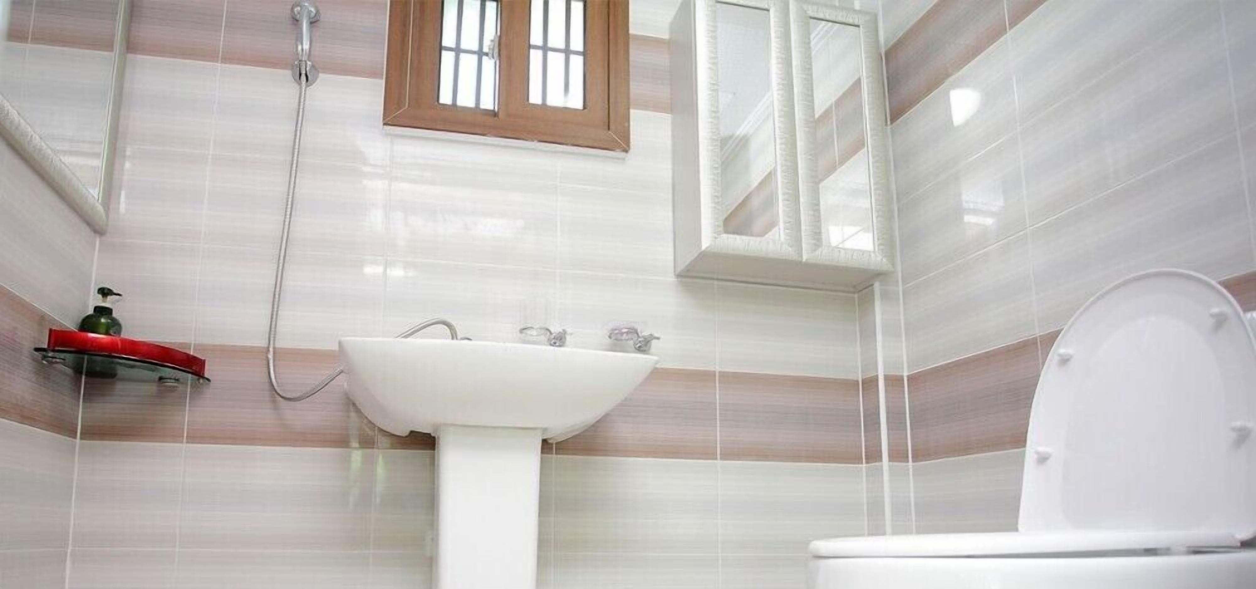 A bathroom with a white sink, a toilet, and a shower.