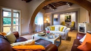 Una sala de estar acogedora con un sofá, sillones, una mesa de centro y una chimenea.