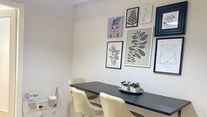 A dining area with a black table, two beige chairs, and a 'No Smoking' sign. - Check Point - Veikou (Athens)