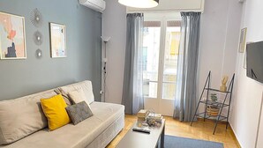 A modern living room with a sofa, a coffee table, and a TV. - Check Point - Veikou (Athens)