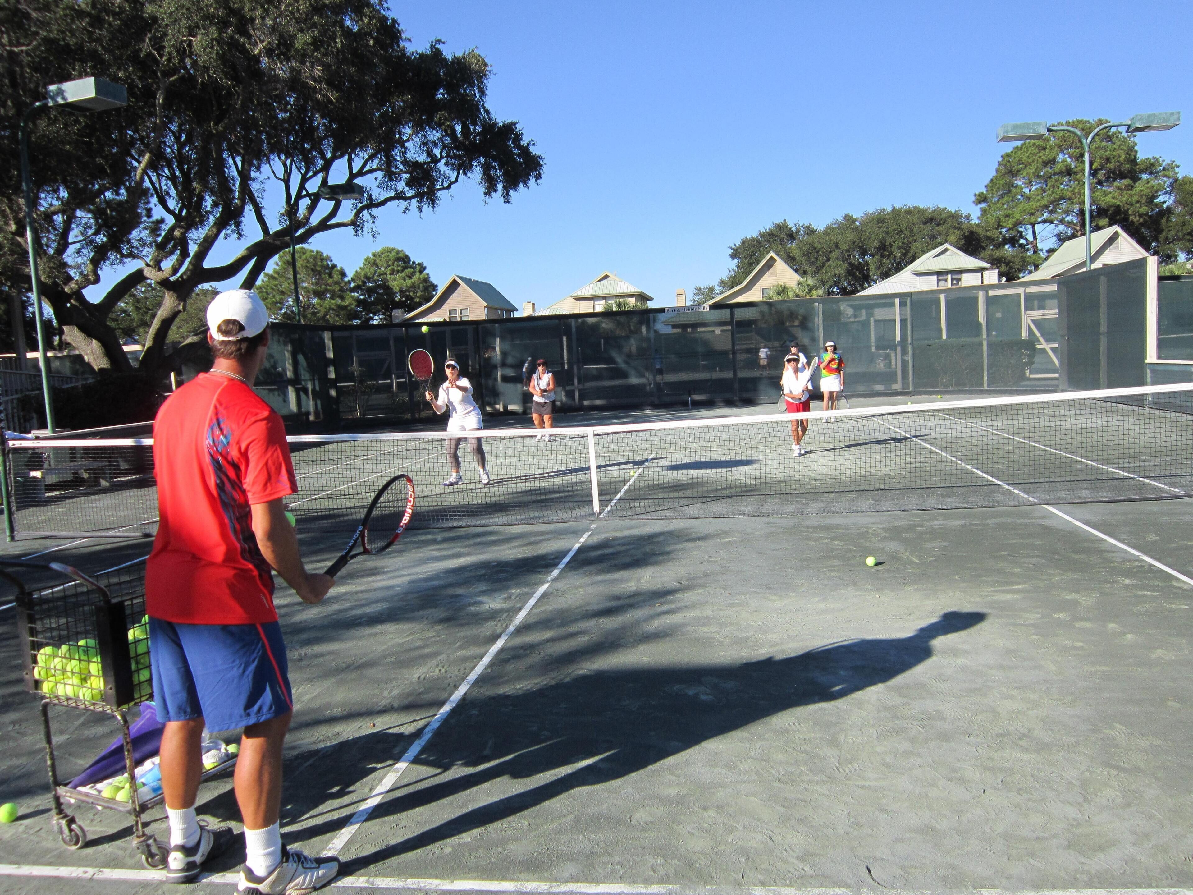 A tennis court with players and a ball.